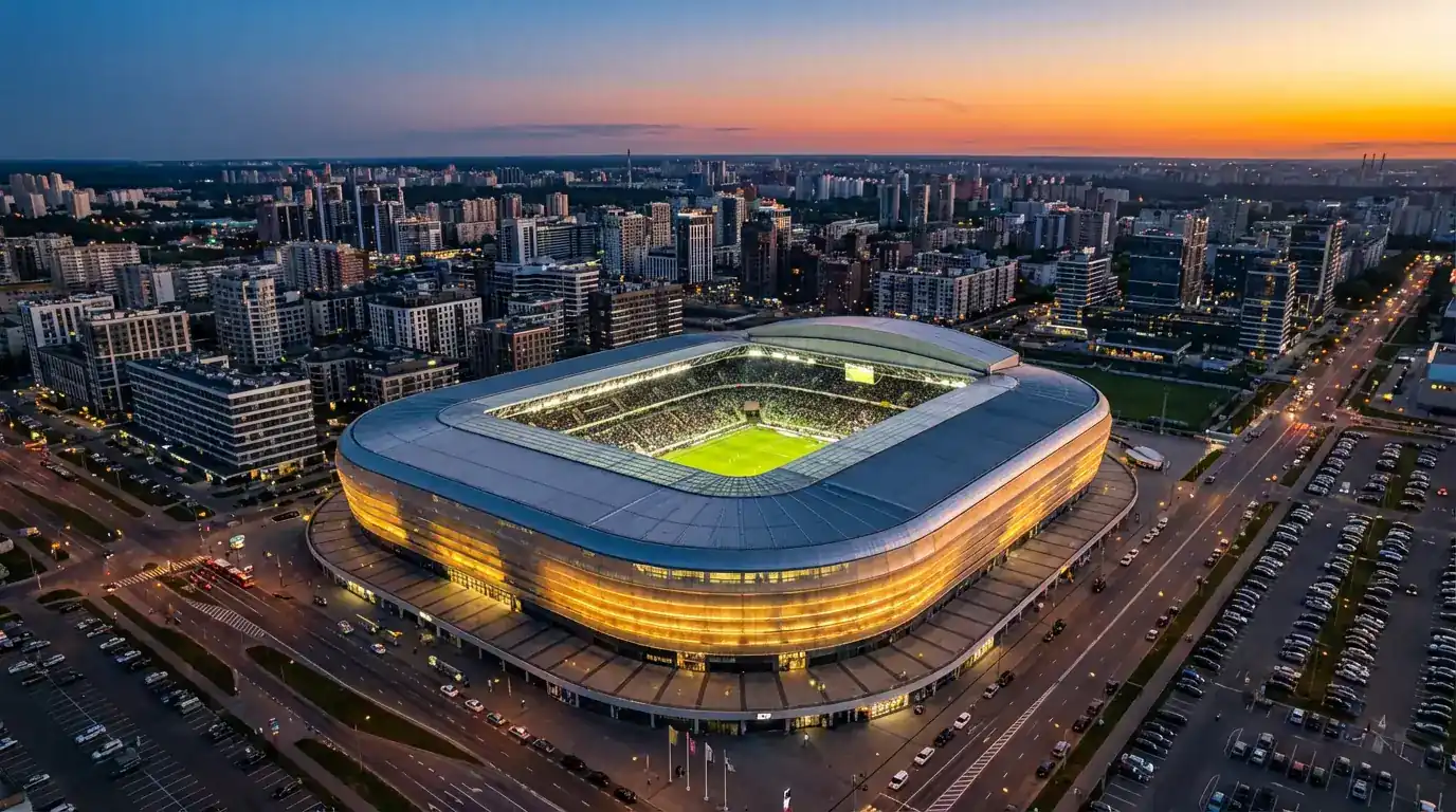 Panorámica de un estadio moderno con césped verde iluminado para un partido nocturno de fútbol internacional